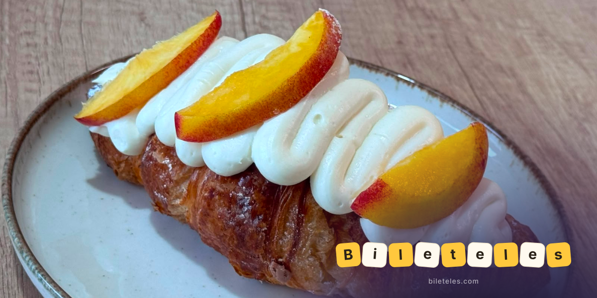 Croissant topped with cream and fresh fruit slices